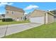 Exterior view of a tan house with a detached garage, green grass and concrete driveway at 154 Old Jackson Rd, Goose Creek, SC 29445