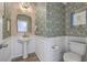 Elegant powder room with unique wallpaper, wainscoting, and a pedestal sink with gold finishes at 159 Lucky Day Dr, Summerville, SC 29486