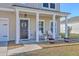 Charming covered porch with rocking chairs, planters, and stylish front door decor at 159 Lucky Day Dr, Summerville, SC 29486