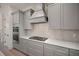 Close-up of the modern stove and custom range hood with stylish cabinets and drawers at 1615 Macoma Rd, Mount Pleasant, SC 29466