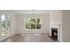 Bright living room with fireplace, French doors to the deck, large window, and light wood floors at 1615 Macoma Rd, Mount Pleasant, SC 29466