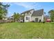 A home's backyard shows a patio with seating, green grass, and a fire pit at 176 Hainsworth Dr, North Charleston, SC 29418