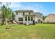 A home's backyard shows a patio with seating, green grass, and a fire pit at 176 Hainsworth Dr, North Charleston, SC 29418