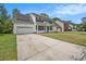 Inviting two-story home with a covered front porch, solar panels, and a long driveway at 176 Hainsworth Dr, North Charleston, SC 29418