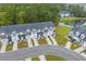 Aerial view of townhouses surrounded by lush greenery, a road, and a serene pond at 178 Buchanan Cir, Goose Creek, SC 29445