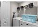 Functional laundry room with washer, dryer, shelving for storage, and a blue laundry basket at 178 Buchanan Cir, Goose Creek, SC 29445