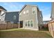 A spacious backyard featuring green grass and a view of a two-story home with muted green siding and white trim at 183 Country Gate Lane Ln, Summerville, SC 29485