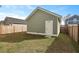 Exterior view of the detached garage featuring green siding, a white door and surrounded by a wooden privacy fence at 183 Country Gate Lane Ln, Summerville, SC 29485