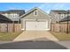 Two car detached garage with white door and surrounded by a wooden privacy fence and adjacent to the main home at 183 Country Gate Lane Ln, Summerville, SC 29485