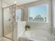 Bright and clean bathroom featuring a shower, tub, and vanity by the window at 185 Red Bluff St, Summerville, SC 29483