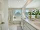 Bright bathroom featuring a double sink vanity, shower, and a soaking tub by the window at 185 Red Bluff St, Summerville, SC 29483