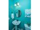Bright blue bathroom featuring a pedestal sink, round mirror, and decorative abstract artwork at 1883 Hall Point Rd, Mount Pleasant, SC 29466