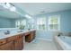 Well-lit bathroom with a double vanity, garden tub, and large windows for natural light at 1883 Hall Point Rd, Mount Pleasant, SC 29466