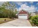 Traditional brick home with a white garage door and a spacious driveway, surrounded by lush landscaping at 201 Island Green Rd, Goose Creek, SC 29445