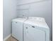 The laundry room contains a white washer and dryer; wire shelves are mounted to the wall at 201 Island Green Rd, Goose Creek, SC 29445