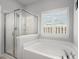 Bathroom view of garden tub and shower with a window and plantation shutters at 206 Alpine Rd, Summerville, SC 29485