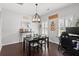 Cozy dining room featuring a modern chandelier, dark wood floors, and ample natural light from the windows at 206 Alpine Rd, Summerville, SC 29485