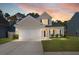 Charming two-story home with a well-manicured lawn and attached two-car garage at sunset at 206 Alpine Rd, Summerville, SC 29485