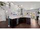 Open concept kitchen with dark cabinets, quartz counters, breakfast bar and views into the living room at 206 Alpine Rd, Summerville, SC 29485