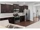 Well-lit kitchen featuring stainless steel appliances, dark wood cabinetry, and quartz countertops on the breakfast bar at 206 Alpine Rd, Summerville, SC 29485
