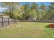 Large, grassy backyard surrounded by a wooden fence and mature trees, providing privacy and space at 210 Sabal Palmetto Ct, Moncks Corner, SC 29461