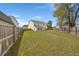 Large backyard featuring lush green grass, a patio set and wood fencing at 210 Sabal Palmetto Ct, Moncks Corner, SC 29461