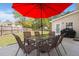 Backyard patio with a glass table and a red umbrella, perfect for outdoor dining and relaxation at 210 Sabal Palmetto Ct, Moncks Corner, SC 29461