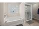 Bathroom featuring a tiled floor, bathtub and a glass-enclosed shower with shelves at 210 Sabal Palmetto Ct, Moncks Corner, SC 29461
