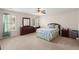 Spacious bedroom with carpet, ceiling fan, windows, dresser, desk, nightstand, and floral bedding at 210 Sabal Palmetto Ct, Moncks Corner, SC 29461