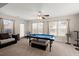 Bright game room filled with natural light, showcasing a pool table, seating, and neutral walls at 210 Sabal Palmetto Ct, Moncks Corner, SC 29461