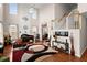 Bright living room with a piano, fireplace, tall windows, and high ceilings filled with natural light at 210 Sabal Palmetto Ct, Moncks Corner, SC 29461