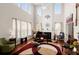 Bright living room with a piano, fireplace, tall windows, and high ceilings filled with natural light at 210 Sabal Palmetto Ct, Moncks Corner, SC 29461