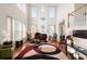 Bright living room with a piano, fireplace, tall windows, and high ceilings filled with natural light at 210 Sabal Palmetto Ct, Moncks Corner, SC 29461