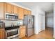 Close up of kitchen with stainless appliances and wooden cabinets and hardwood floor at 2244 Ashley Crossing Dr # 1232, Charleston, SC 29414