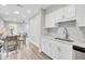 Bright kitchen featuring white cabinets, stainless steel sink, and an adjacent dining area with wood flooring at 2325 Sorentrue Ave, North Charleston, SC 29405