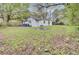 View of the backyard featuring lawn, trees, and a charming home with a fire pit at 2916 Louise Dr, North Charleston, SC 29405