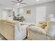 Bright, open-concept living room with modern ceiling fan, wood flooring, neutral-colored furniture, and dining area at 2916 Louise Dr, North Charleston, SC 29405