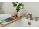 Close-up of a luxurious bathtub with a bamboo tray holding bath essentials for a relaxing spa day at home at 2951 Clearwater Dr, Mount Pleasant, SC 29466