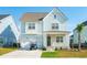 Charming light blue two-story home with a front porch, garage, and driveway with golf cart at 2951 Clearwater Dr, Mount Pleasant, SC 29466