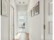 Bright hallway showcasing hardwood floors, white trim, and decorative wall art at 2951 Clearwater Dr, Mount Pleasant, SC 29466