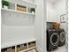 Mudroom features white wainscoting, bench seating, storage, and modern washer and dryer at 2951 Clearwater Dr, Mount Pleasant, SC 29466