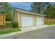 Two-car garage with white doors and well-maintained landscaping at 2952 Sweetleaf Ln, Johns Island, SC 29455