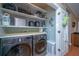 Laundry room with two LG washing machines and well organized shelves for easy use at 2952 Sweetleaf Ln, Johns Island, SC 29455