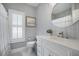 Stylish bathroom featuring a modern vanity with a round mirror, unique wallpaper, and elegant fixtures at 3075 Maritime Forest Dr, Johns Island, SC 29455