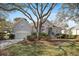 Charming home featuring a well-manicured lawn, mature trees, and a classic stucco facade at 3075 Maritime Forest Dr, Johns Island, SC 29455
