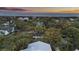 An aerial view shows a charming beach neighborhood with lush trees and beautiful homes near the ocean at sunset at 3304 Hartnett Blvd, Isle of Palms, SC 29451