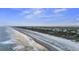 Expansive beach view from above showcasing tranquil waves, a sandy shoreline, and a charming coastal community at 3304 Hartnett Blvd, Isle of Palms, SC 29451