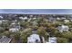 This aerial shot shows a coastal community near the beach with tree-lined streets and various home styles at 3304 Hartnett Blvd, Isle of Palms, SC 29451