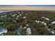 A captivating aerial view reveals a community of homes nestled amidst lush trees with the beach stretching out in the background at 3304 Hartnett Blvd, Isle of Palms, SC 29451