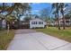 Home's exterior with a paved driveway, grass lawn and privacy fence, and lush landscaping at 3304 Hartnett Blvd, Isle of Palms, SC 29451